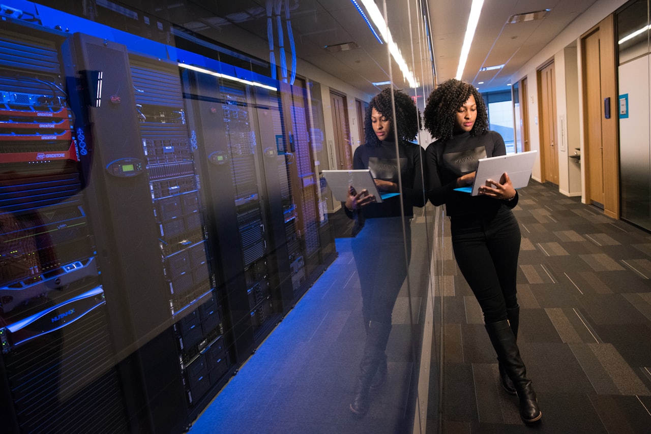 Technician with a laptop beside server racks